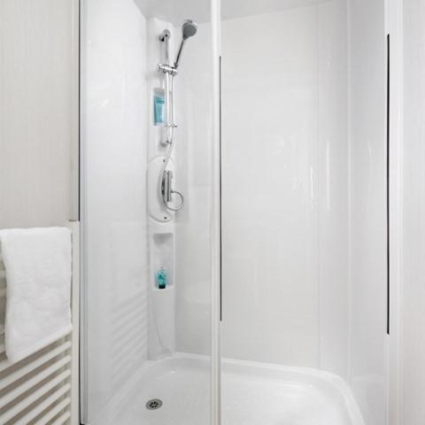 a shower with a glass door in a bathroom at The Trout Van - Beautiful, luxury static caravan in Aberlour