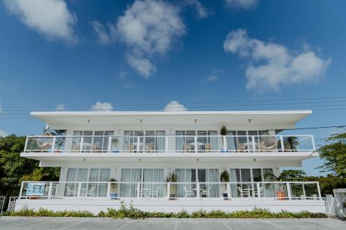 a white building with balconies and tables and chairs at Beachfront Bella Horizonte 7 in Savaneta