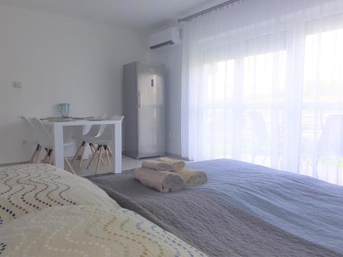 1 dormitorio con 1 cama con toallas en Liliom apartman, en Hévíz