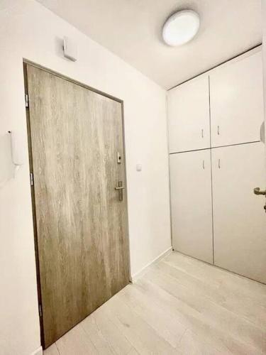 duże drewniane drzwi w pokoju z białymi ścianami w obiekcie 01 Gdańsk Oliwa - Apartament Mieszkanie dla 4 os w Gdańsku