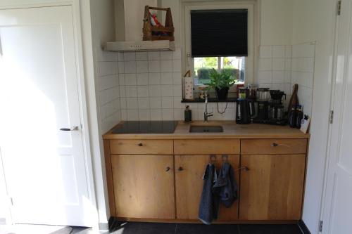 a kitchen with a sink and a counter top at De Parel B&B in Breezand