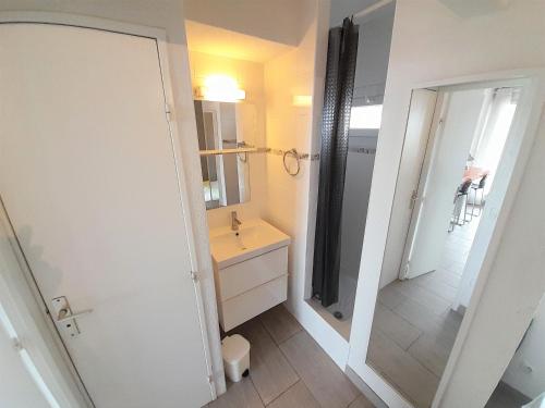 ein Bad mit einem Waschbecken und einem Spiegel in der Unterkunft Appartement Village Naturiste Tornado in Cap d'Agde