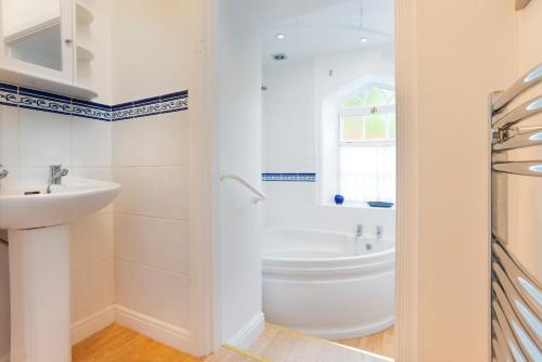 a white bathroom with a tub and a sink at 5 Lowfield, Ambleside in Ambleside
