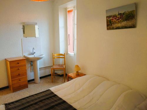 une chambre avec un lit et un lavabo dans l'établissement 5COMA4 Appartement vue sur mer, à Collioure