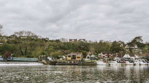 a group of boats docked at a dock on a lake at Island Hut - Outdoor bath tub, firepit and water equipment in Saltford