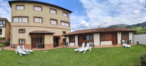 a large building with lawn chairs in front of it at Apartamentos El Sol in Potes