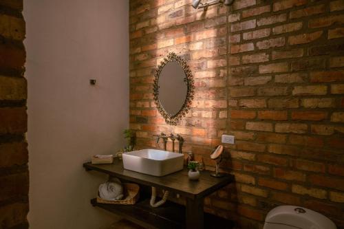 a bathroom with a sink and a brick wall at Posada la Serena in Villa de Leyva