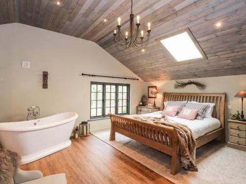 a bedroom with a large bed and a bath tub at The Hare's Shack in Kendal