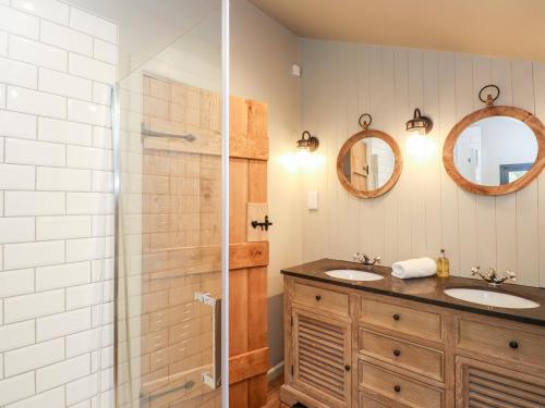 ein Bad mit 2 Waschbecken und einer Dusche in der Unterkunft The Hare's Shack in Kendal