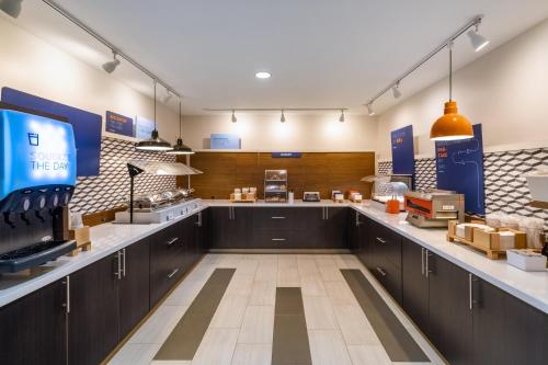 a large kitchen with black cabinets and a counter at Holiday Inn Express Hotel & Suites Talladega by IHG in Talladega
