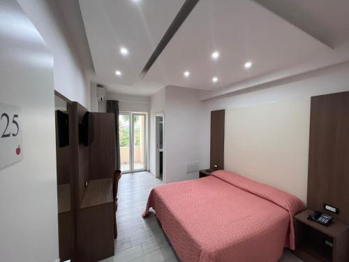 um quarto com uma cama com um cobertor rosa em Hotel La Mela em Varcaturo