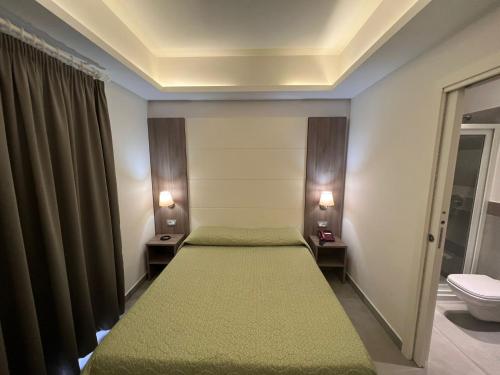 a bedroom with two beds and a toilet at Hotel La Mela in Varcaturo