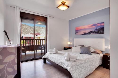 een slaapkamer met een bed en een balkon bij LOVELY MOCAN, Pool, Fast Wi-Fi, Padel Court in Palm-mar