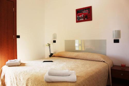a bedroom with a bed with two towels on it at Fellini Rimini in Rimini