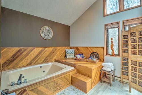 a bathroom with a large tub in a room with wooden walls at Poconos Home with Private Spa and Fire Pit in Long Pond