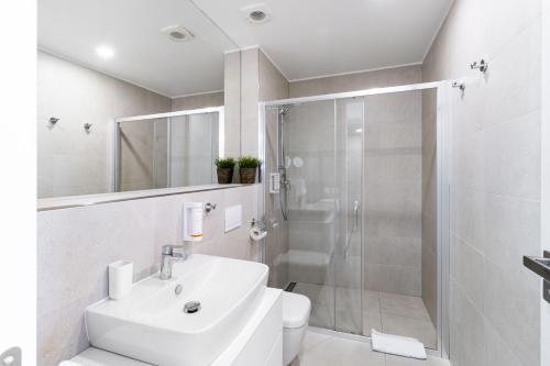 a white bathroom with a sink and a shower at Apartmán v Tee house Čeladná in Čeladná