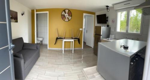 a kitchen and living room with a couch and a table at SUPERBE APPARTEMENT AU CALME in Sainte-Féréole