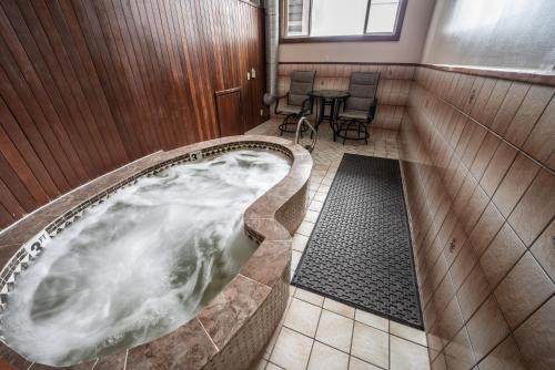 jacuzzi en una habitación con mesa y sillas en Clover Creek Inn en Montpelier