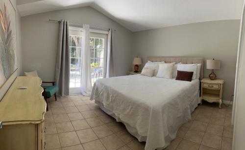 ein Schlafzimmer mit einem großen weißen Bett und einem Fenster in der Unterkunft Private Villa with outside garden walk to the bay and Ringling Museum minutes from downtown in Sarasota
