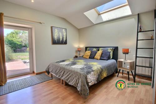 a bedroom with a bed and a window at Aux Matins du Bonheur in Surzur