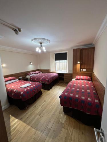 a hotel room with two beds and a tv at Smiths Hotel in Glasgow