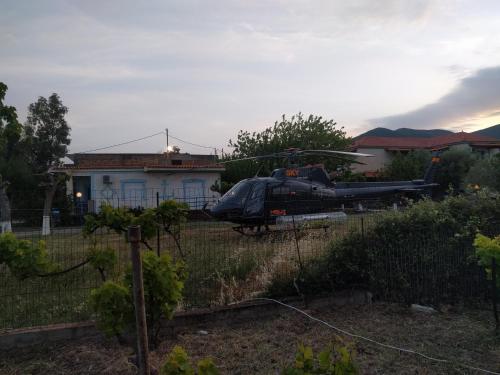 a helicopter parked in a field in front of a house at Holiday Tolofona Beach in Eratini