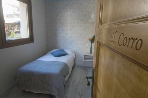 a bedroom with a bed and a door with the words el comino at Casa Rural Mugarri in Poveña