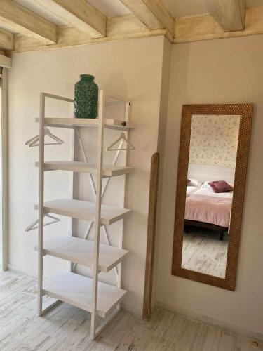 a white book shelf in a room with a mirror at Casa Rural Mugarri in Poveña