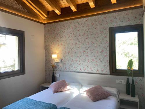 a bedroom with two beds and two windows at Casa Rural Mugarri in Poveña