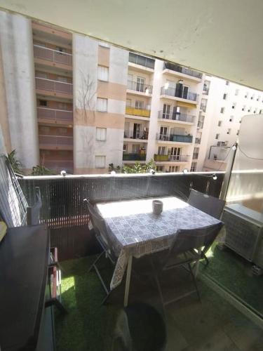 - une table et des chaises sur un balcon avec des bâtiments dans l'établissement studio climatisé, 50 m de la prom, Wifi, à Nice