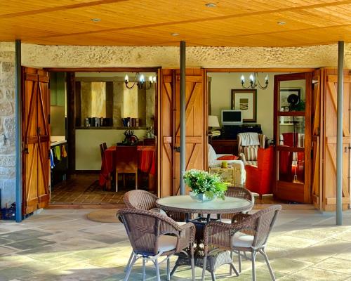 a patio with a table and chairs and a living room at Torre del Marqués Hotel Spa & Winery - Small Luxury Hotels in Monroyo