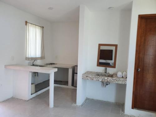 a white bathroom with a sink and a mirror at Riviera Bonfil in Acapulco