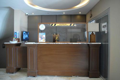 a lobby with a counter with a clock on it at Sunday Beach Hotel in Kusadası