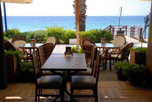 a restaurant with tables and chairs and the ocean at Sunday Beach Hotel in Kusadası