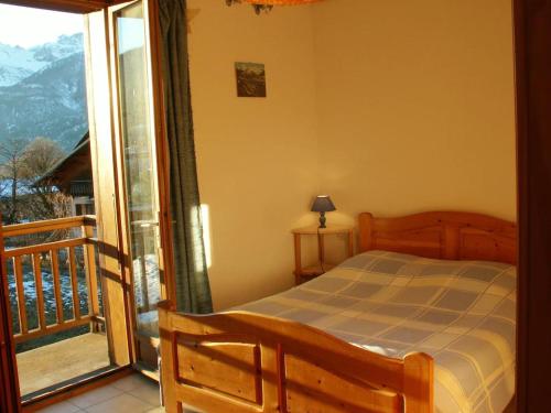 ein Schlafzimmer mit Bett und Balkon mit Aussicht in der Unterkunft Maison spacieuse à Villar-Saint-Pancrace avec vue montagne in Villar-Saint-Pancrace