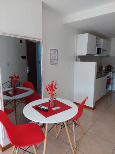sala de estar con 2 mesas y sillas rojas en Urquiza 949 en Rosario