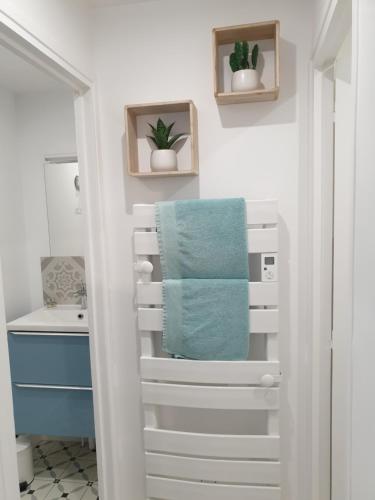 a bathroom with a towel rack and a sink at Le Gîte Senlisien in Senlis