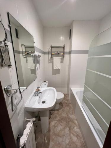 a bathroom with a sink and a toilet and a tub at Hostal La Ruta in Caín