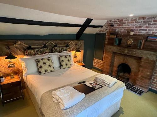 a bedroom with a large bed with a fireplace at Castle Inn in West Lulworth