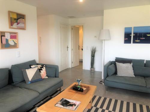 a living room with two couches and a coffee table at Faraway Falésia in Olhos de Água