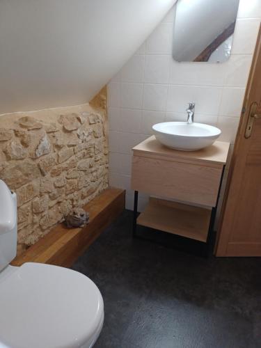 une salle de bain avec un lavabo et des toilettes dans l'établissement Gîtes Le clos de Veyrignac, à Veyrignac