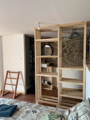 - une chambre avec une étagère en bois et un lit dans l'établissement Chez LULU appartement de caractère, à Cozzano