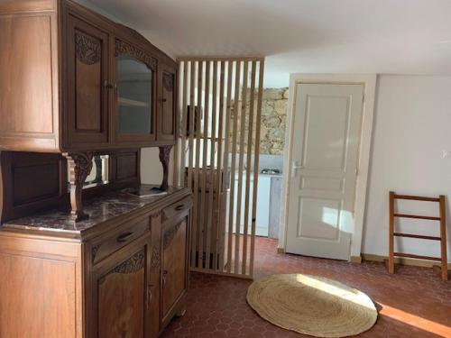 - une cuisine avec des placards en bois et un tapis au sol dans l'établissement Chez LULU appartement de caractère, à Cozzano
