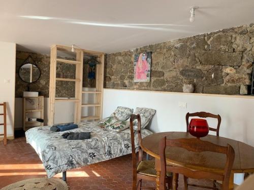 um quarto com uma cama e uma mesa com cadeiras em Chez LULU appartement de caractère em Cozzano