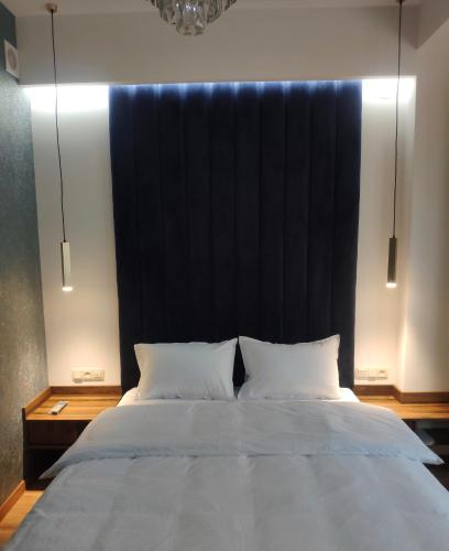 a bedroom with a large bed with a black headboard at Отель AuRoom Ванадзор in Vanadzor