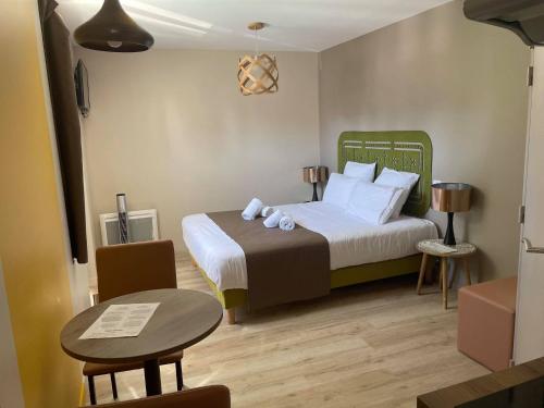 サン・ジャン・ド・モンにあるHôtel Casita del Marのベッドルーム1室(大型ベッド1台、テーブル、テーブル付)