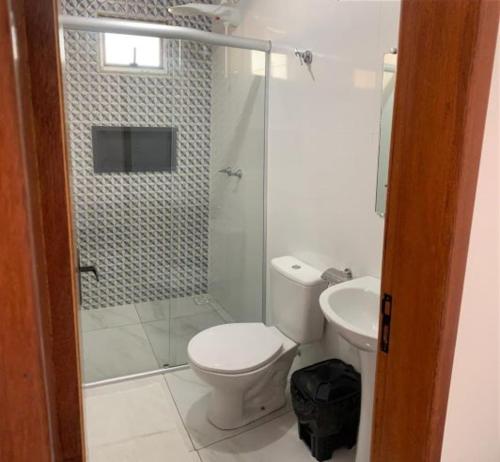 a bathroom with a shower and a toilet and a sink at POUSADA FÊNIX in Viçosa