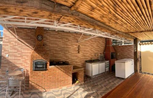 une cuisine avec un mur en briques, une table et des chaises dans l'établissement POUSADA FÊNIX, à Viçosa