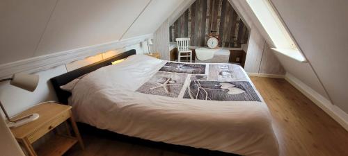 - une chambre avec un lit et un escalier avec une table dans l'établissement Holiday apartment with free parking Boven Jan Enkhuizen, à Enkhuizen