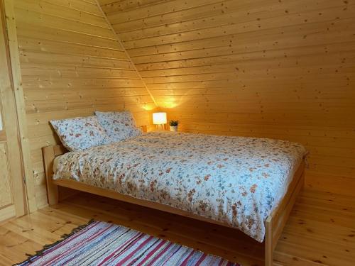 ein Schlafzimmer mit einem Bett in einer Holzhütte in der Unterkunft Domek na Wsi in Bodzentyn